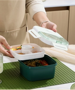 Detail view of double-layer lunch box with four compartments and dark green bottom container