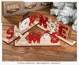 Dettaglio di decorazioni natalizie rustiche in legno con scritte SNOW, XMAS e NOEL