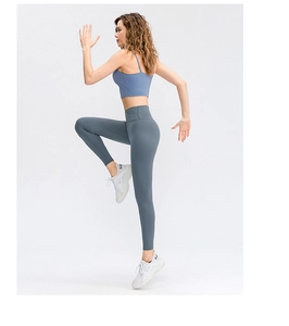 Detalle de la cintura alta cruzada y el tejido azul suave de los leggings de yoga