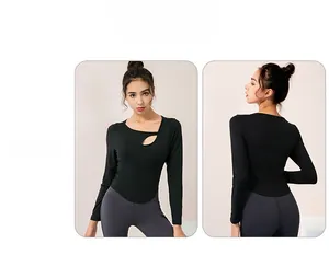 Detail of black slim fit yoga top with asymmetric teardrop cutout and curved hem