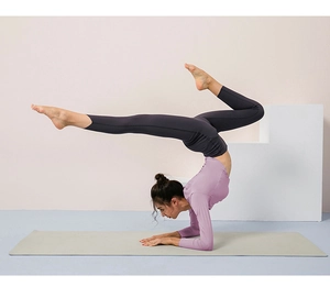 Detail showing flexible fabric of purple long sleeve yoga top during intense stretching