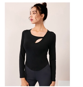 Close-up of black yoga top showing asymmetric cutout detail and high-stretch fabric
