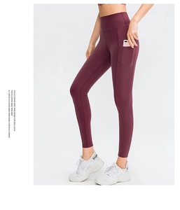 Detail van hoge taille yoga legging in wijnrood met handige zijzakken voor sport