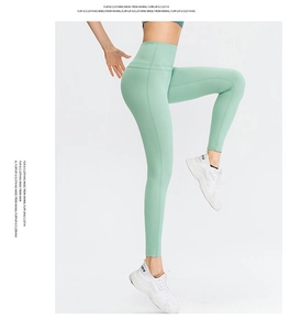 Close-up of mint green high-waisted yoga leggings showing elastic compression fabric
