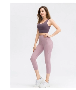Detail of high-waisted yoga leggings with side pockets in soft lavender stretch fabric