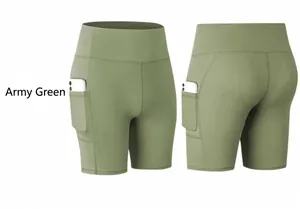 Detail view of army green high-waisted yoga shorts with side phone pockets and elastic fabric