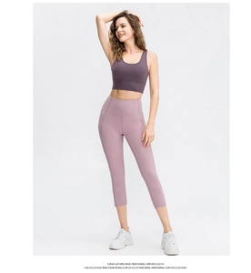 Detail of high-waist yoga capris with functional side pocket and purple sports bra