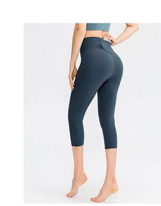 Detail of high-waist yoga capris showing a functional hidden back pocket with a smartphone