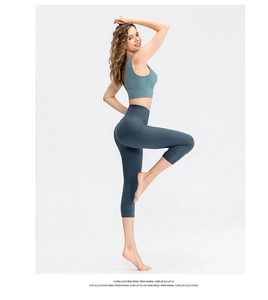 Detail view of high-waisted yoga capris with side pocket in dark teal stretch fabric