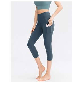 Close-up of high-waisted yoga pants featuring functional side phone pockets for workouts