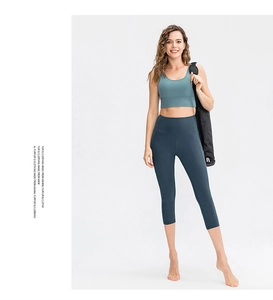 Detail of high-stretch dark cyan high-waisted yoga capris and matching sports bra set