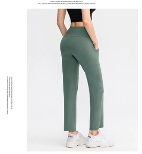 Detail of high-waisted dark green yoga pants showing side pocket and elastic fabric