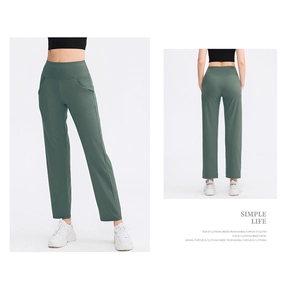 Detail of high-waisted loose yoga pants in dark green with functional side pockets