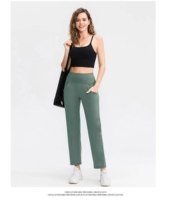 Sage green high-waisted wide-leg yoga pants with side pockets and a black tank top