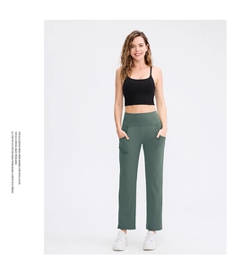 Detail of high-waist loose yoga pants with side pockets and elastic athletic fabric