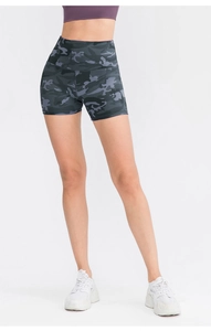 Detail of high-waist yoga shorts with dark camouflage print and elastic compression fabric
