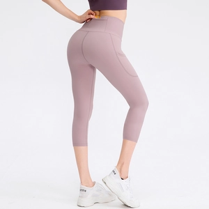 Women's high-waisted pink 3/4 yoga leggings with side pockets and smooth compression fit
