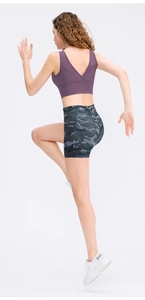 Close-up of high-waisted gray camouflage sports shorts and purple cross-back yoga bra