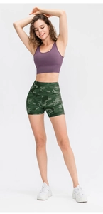 Detailed view of high-waisted green camo print sports shorts and purple sports bra set