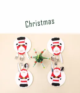 Dettaglio di quattro portaposate Babbo Natale su piatti bianchi per decorazione natalizia
