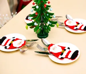 Dettaglio di portaposate a forma di Babbo Natale su piatti bianchi per tavola natalizia