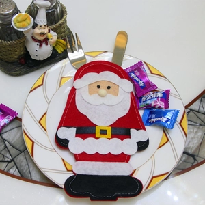 Dettaglio del porta posate Babbo Natale su piatto bianco per decorazione tavola natalizia