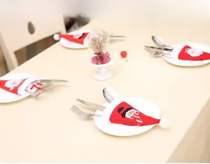 Detail of red Christmas hat cutlery holder with snowman embroidery on dining table