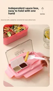 Pink bento box detail showing the leakproof sauce compartment and included fork