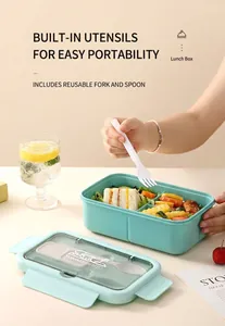 Close-up of mint green double-layer bento box with built-in cutlery and food sections