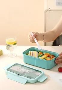 Close-up of mint green double-layer bento box with built-in cutlery and food sections