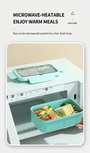 Detail of mint green bento box with 3 compartments being taken out of a microwave