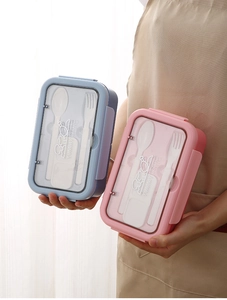 Detail of bento box set with airtight lid compartments and included white utensils