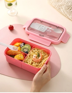 Pink bento box detail with two compartments and transparent lid for cutlery storage
