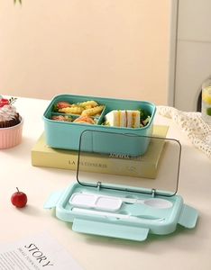 Detail of partitioned lunch box with cutlery storage and fresh salad meal layout