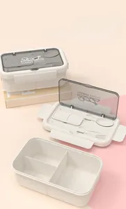 Close-up of three-compartment bento box with built-in utensils and YUMMY BENTO lid logo