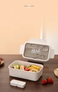 Vue détaillée d'une boîte à lunch bicolore avec couverts et repas sur table en bois