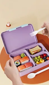 Three-compartment purple lunch box with blue lid filled with sushi, sandwich, and fruit