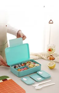 Detail of mint green bento lunch box with three compartments and matching utensils