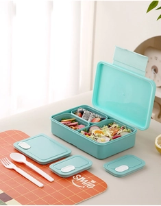 Detail view of mint green divided lunch box set with secure lids and reusable utensils