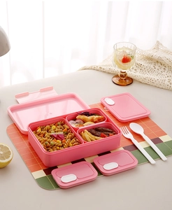 Pink 3-compartment bento box with utensils and vent valve on a plaid tablecloth