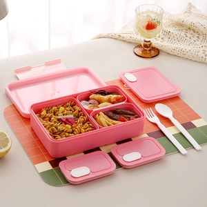 Pink compartmentalized lunch box with utensils and divided food sections for daily use