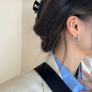 Polished silver heart-shaped chunky hoop earrings for women in a minimalist modern design