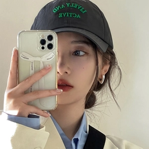 Mirror selfie showing a grey baseball cap with green embroidery detail and cotton texture