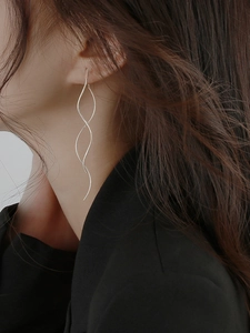 Close-up of S925 silver wave tassel earrings on model showing a long spiral design