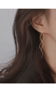 Detailed view of elegant wavy long line earrings in gold finish on female model