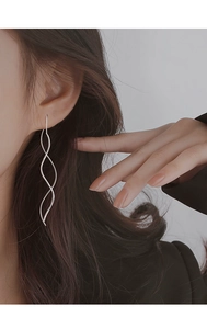 Detailed close-up of elegant S925 sterling silver wave drop earrings on model