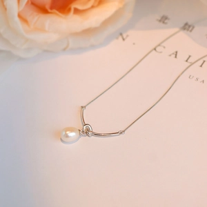 Elegante S925 Silberknoten Perlenhalskette mit glänzendem Anhänger auf floralem Hintergrund