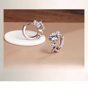 Detail of S925 sterling silver hoop earrings with round cut stones and polished finish