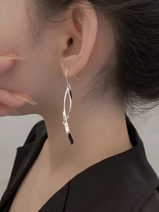 Detail of S925 silver minimalist tassel earrings with geometric twisted long streamline design