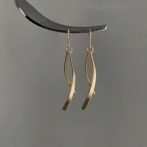 Modern S925 silver long tassel threader earrings with matte gold finish on a fork